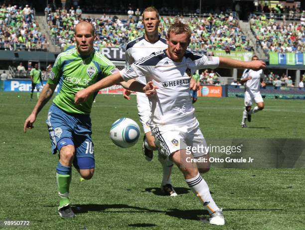 Chris Birchall of the Los Angeles Galaxy dribbles against Freddie Ljungberg of the Seattle Sounders FC on May 8, 2010 at Qwest Field in Seattle,...