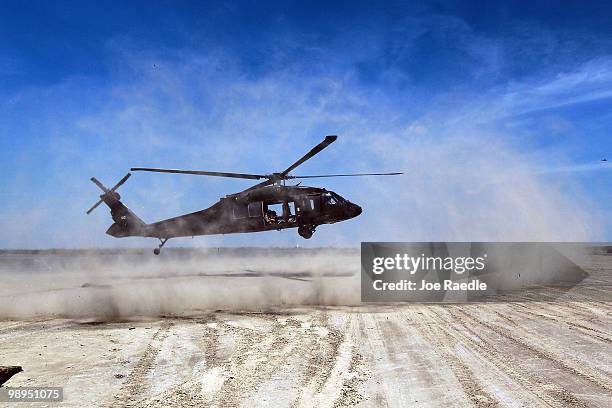 Louisiana National Guard helicopter lands on the beach after airlifting sling load sand bags into place as they create a barrier in an attempt to...