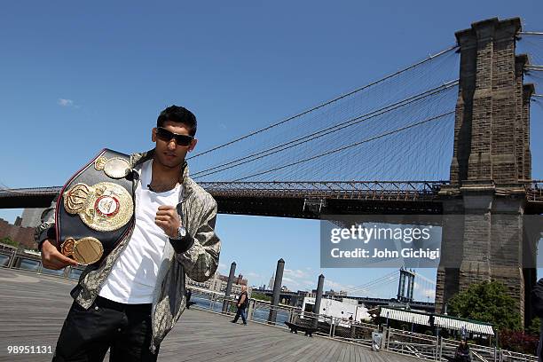 British boxer Amir Khan poses with the WBA World light welterweight championship belt in front of the Brooklyn Bridge on May 10, 2010 in the Brooklyn...