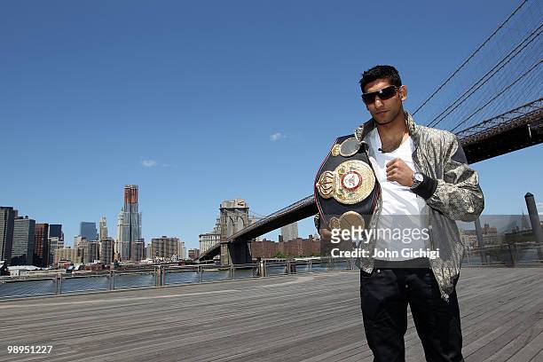British boxer Amir Khan poses with the WBA World light welterweight championship belt in front of the Brooklyn Bridge on May 10, 2010 in the Brooklyn...