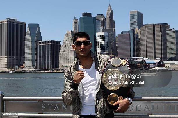 British boxer Amir Khan poses with the WBA World light welterweight championship belt by the Brooklyn Bridge on May 10, 2010 in the Brooklyn borough...
