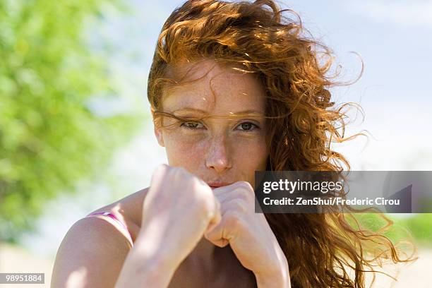 young woman holding clenched fists toward camera - 自衛 ストックフォトと画像