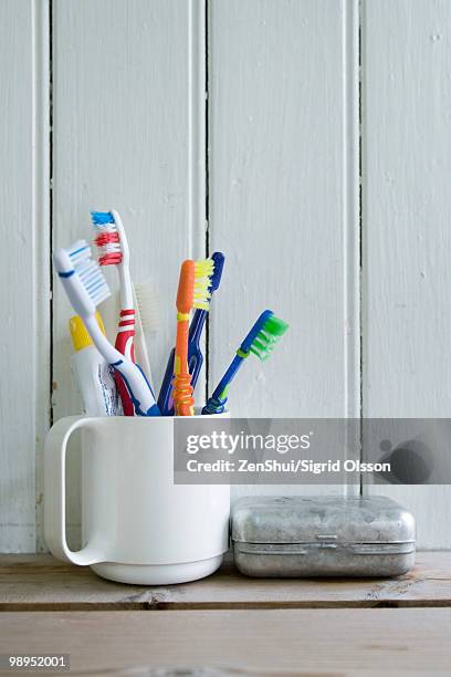 toothbrushes in mug on shelf - toothbrush bildbanksfoton och bilder