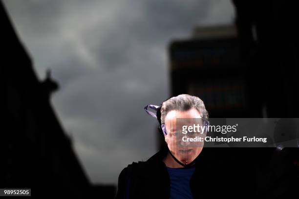 An electoral reform protester wears a mask depecting David Cameron as they gather outside the Workers Foundation in Westminster on May 10, 2010 in...