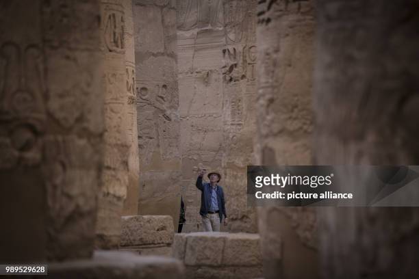 Picture issued on 24 December 2017, shows a tourist taking pictures of the hall of columns at the Karnak Temple, in Luxor, Upper Egypt, 08 December...