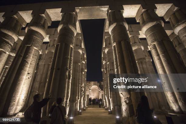 Picture issued on 24 December 2017, shows the tourists taking photos of the illuminated processional Colonnade of Amenhotep III during a light show...
