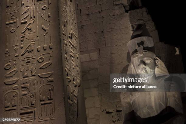 Picture issued on 24 December 2017, shows tourists taking photos of the illuminated columns of Amenhotep III during a light show at the Luxor Temple...
