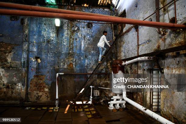 In this photograph taken on June 27 an Indian labourer works in an ice factory in Noida, some 20km east of New Delhi. Keeping people cool in Delhi's...