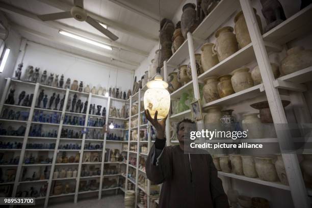 Photo made available on 26 December 2017, shows an Alabaster salesman showing a newly hand made Alabaster lantern inside his shop, in Gurna village,...