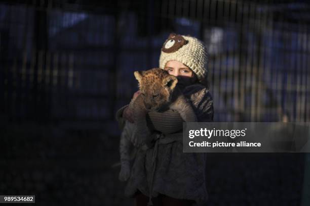 Girl carries a lion cub at a zoo in Rafah, Southern Gaza Strip, the Palestinian Territories, 25 December 2017. According to officials, three...