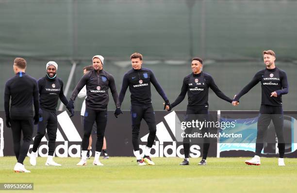 Danny Rose of England ,Kyle Walker of England, Dele Alli of England , Trent Alexander-Arnold of England and Gary Cahill of England hold hands while...