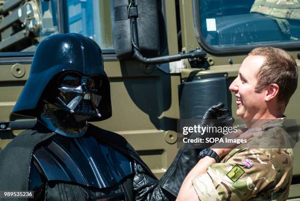 Man cosplaying as Star Wars villain Darth Vader poses with a soldier and pretends to be choking in with his mind. Stirling shows its support of the...