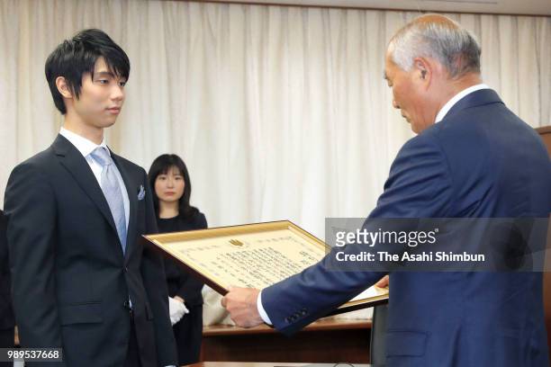 Two-time Olympic figure skating Men's Singles gold medalist Yuzuru Hanyu receives certificate of appreciation from the Reconstriction Minister...