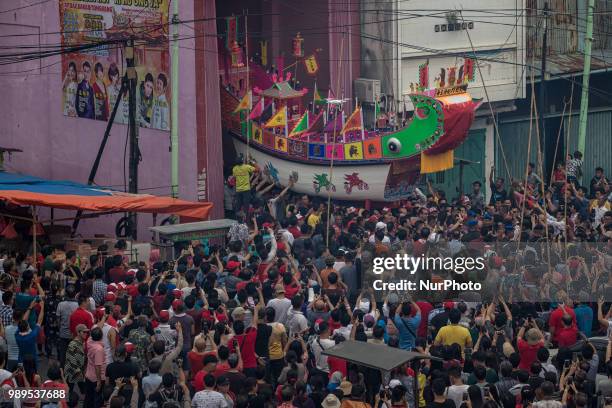 People participate in Bakar Tongkang Festival or the barge burning tradition in Bagansiapi-Api, Riau, Indonesia, on June 30, 2018. A paper barge is...