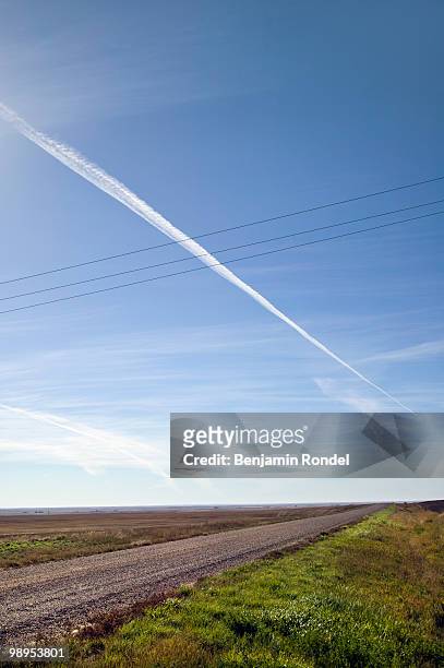 jet trails over country road - benjamin rondel stock pictures, royalty-free photos & images