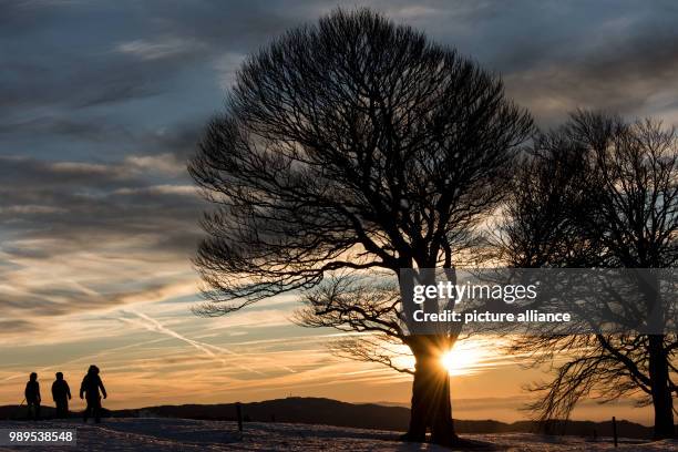 People watch the sunset near Horben, Germany, 25 December 2017. Photo: Patrick Seeger/dpa