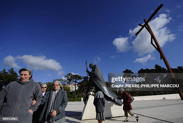 Nuns walk next to a sculpture representing Pope John Paul II at Fatima's Sanctuary on May 10, 2010. Pope Benedict XVI will visit Portugal from 11 to...