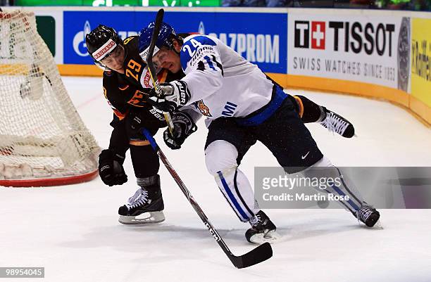 Alexander Barta of Germany and Sami Kapanen of Finland battle for the puck during the IIHF World Championship group A match between Germany and...