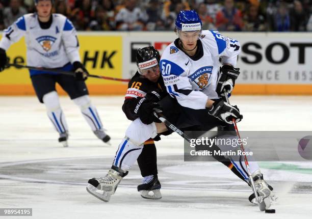 Michael Wolf of Germany and Juhamatti Aaltonen of Finland battle for the puck during the IIHF World Championship group A match between Germany and...