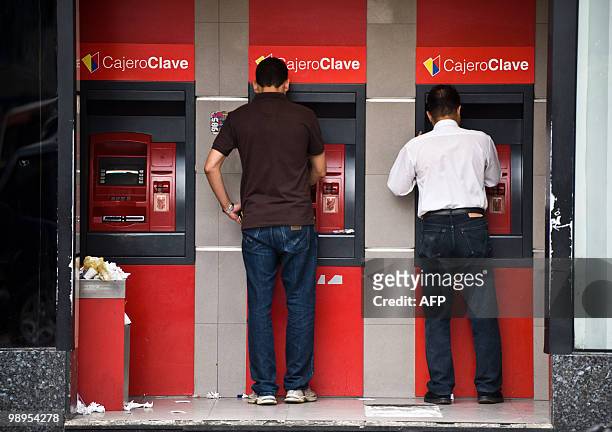 People withdraw money from a cash dispenser in Caracas, May 10, 2010. From April 2009 to April 2010, the prices in Venezuela increased in 30.4...
