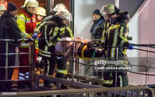 Rescue personnel carry an injured passenger off the damaged excursion ship "Swiss Crystal", after it has crashed into a supporting pillar of the A42...