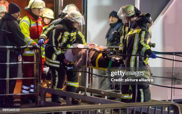 Dpatop - Rescue personnel carry an injured passenger off the damaged excursion ship "Swiss Crystal", after it has crashed into a supporting pillar of...