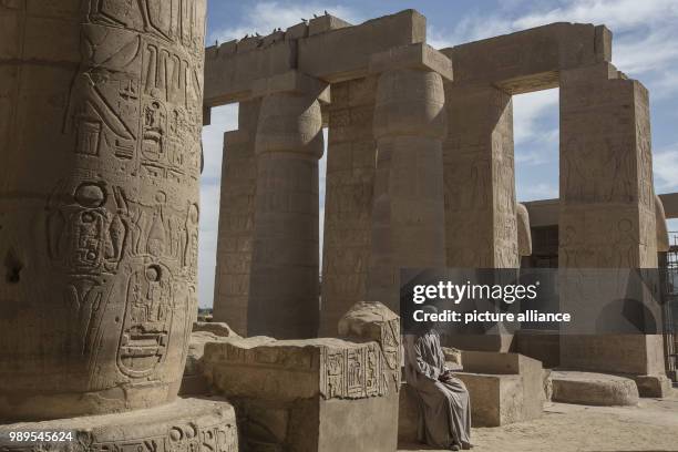 Picture provided on 28 December 2017 shows a temple guard sitting inside the Ramesseum Temple, the memorial temple of Pharaoh Ramesses II, in Luxor,...