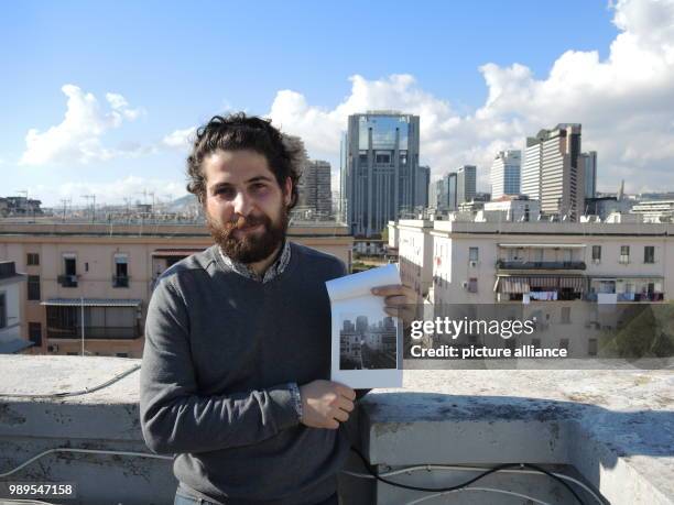 The Italian photographer Ottavio Sellitti shows one of his pictures he took of the district on a rooftop terrace in the Rione Luzzatti district in...