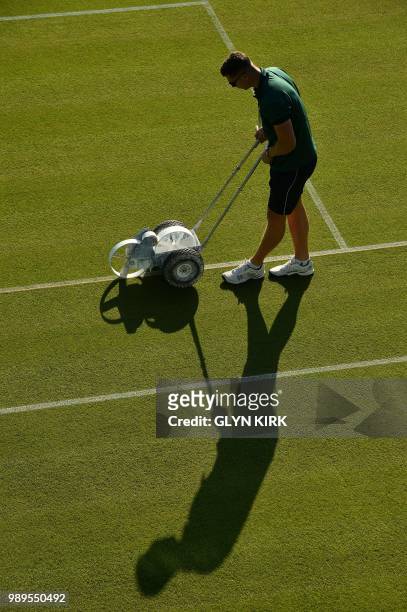Groundsworkers tend to the grass courts at The All England Tennis Club in Wimbledon, southwest London, on July 2 on the first day of the 2018...