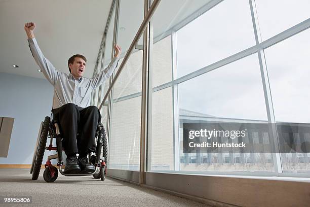 businessman with spinal cord injury in a wheelchair with his arms raised - spinal cord injury stock-fotos und bilder