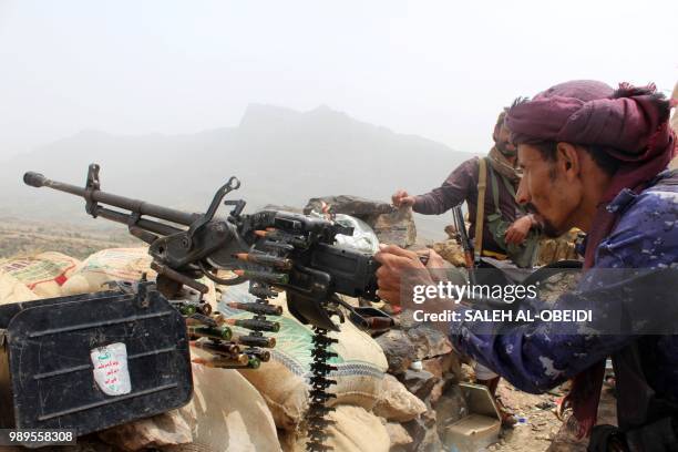 Yemeni pro-government fighter fires a heavy machine gun as Emirati supported forces take over Huthi bases on the frontline of Kirsh between the...