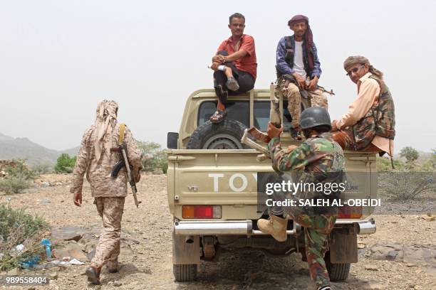 Yemeni pro-government fighters sit at the back of an armed pick-up as Emirati supported forces take over Huthi bases on the frontline of Kirsh...