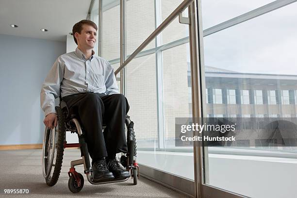 businessman with spinal cord injury in a wheelchair in an office building - spinal cord injury stock-fotos und bilder