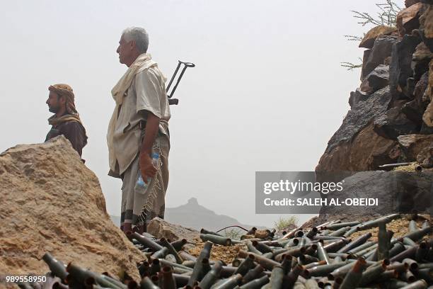 Yemeni pro-government fighters stand by cartridge cases as Saudi and Emirati supported forces take over Huthi bases on the frontline of Kirsh between...