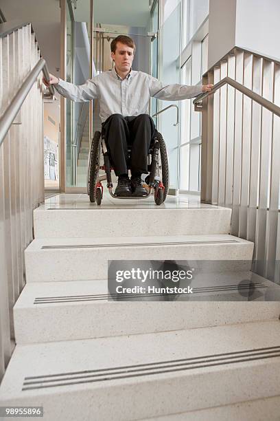 businessman with spinal cord injury in a wheelchair at the top of stairs - spinal cord injury stock-fotos und bilder