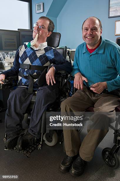 two businessmen in an office, one with muscular dystrophy and breathing ventilator and another with friedreich's ataxia - duchenne muscular dystrophy bildbanksfoton och bilder