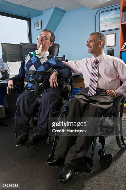 two businessmen in an office, one with muscular dystrophy and breathing ventilator and another with spinal cord injury - spinal cord injury stock-fotos und bilder