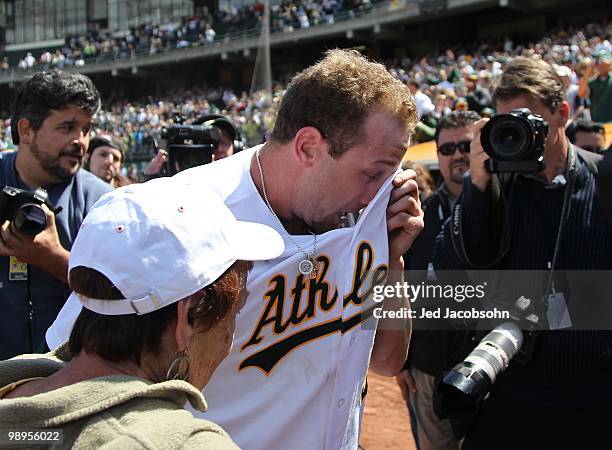 Dallas Braden of the Oakland Athletics celebrates after pitching a perfect game against the Tampa Bay Rays with his grandmother Peggy Lindsey during...
