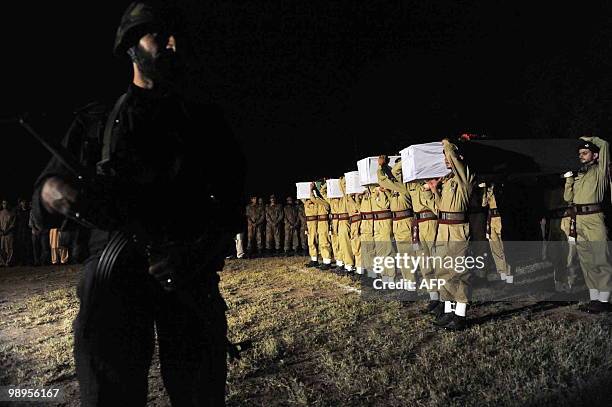 Pakistani soldiers carry coffin of their comrades killed in a military operation against militants, during a funeral ceremony in Peshawar on May 10,...