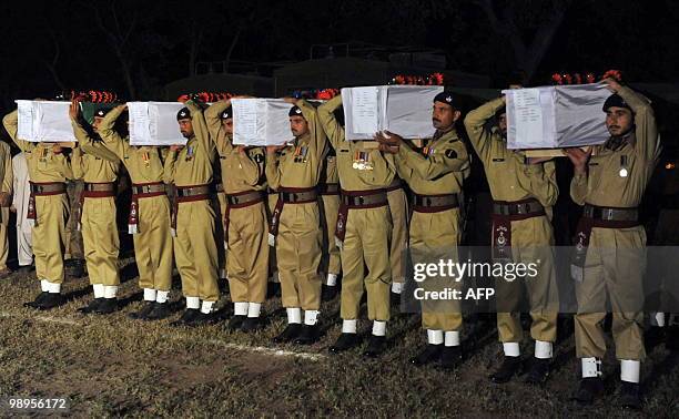 Pakistani soldiers carry coffin of their comrades killed in a military operation against militants, during a funeral ceremony in Peshawar on May 10,...