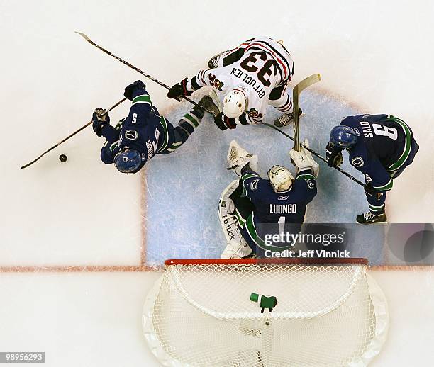 Sami Salo and Roberto Luongo of the Vancouver Canucks and Dustin Byfuglien of the Chicago Blackhawks look on as Christian Ehrhoff of the Vancouver...