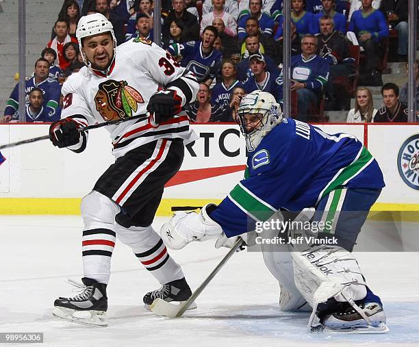 Dustin Byfuglien of the Chicago Blackhawks stands in front of Roberto Luongo of the Vancouver Canucks in Game Four of the Western Conference...