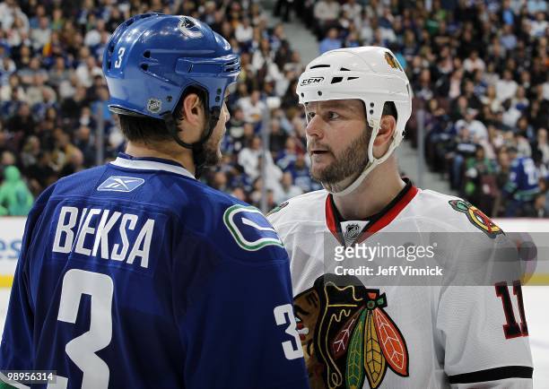 Kevin Bieksa of the Vancouver Canucks and John Madden of the Chicago Blackhawks stare at each other in Game Four of the Western Conference Semifinals...