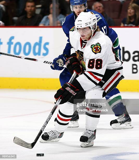 Ryan Kesler of the Vancouver Canucks looks on as Patrick Kane of the Chicago Blackhawks skates up ice with the puck in Game Four of the Western...