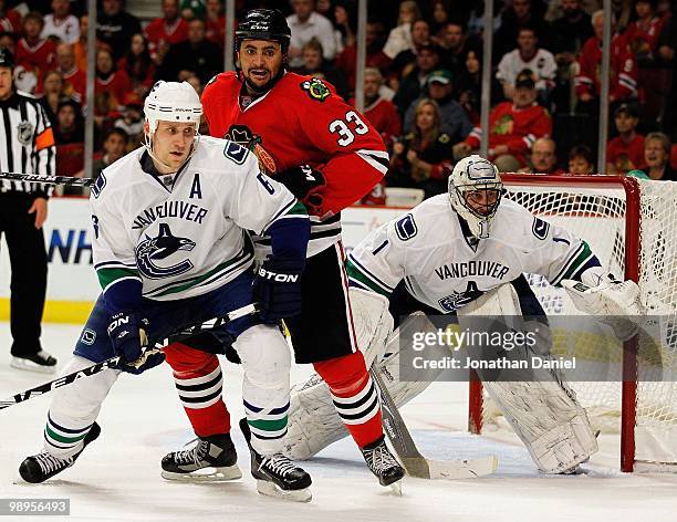 Dustin Byfuglien of the Chicago Blackhawks places himself between Sami Salo and Roberto Luongo of the Vancouver Canucks in Game Five of the Western...