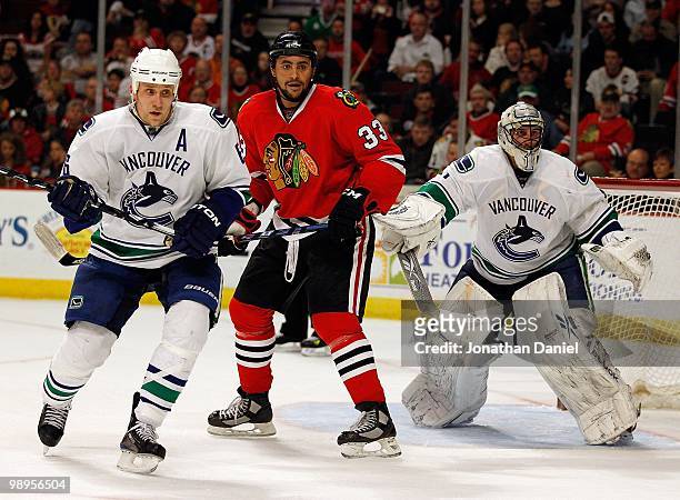 Dustin Byfuglien of the Chicago Blackhawks places himself between Sami Salo and Roberto Luongo of the Vancouver Canucks in Game Five of the Western...