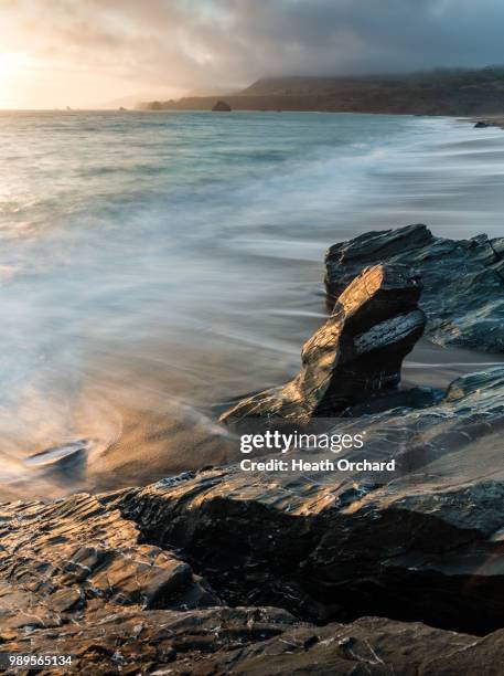 a rocky ocean coast at sunset. - orchard beach stock pictures, royalty-free photos & images