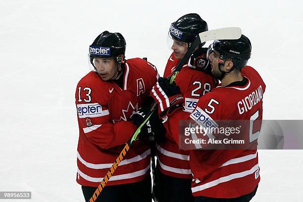 Marc Giordano of Canada celebrates his team's second goal with team mates Kyle Cumiskey and Ray Whitney during the IIHF World Championship group B...