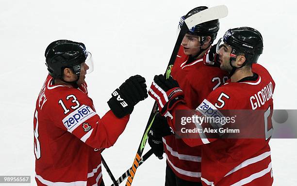 Marc Giordano of Canada celebrates his team's second goal with team mates Kyle Cumiskey and Ray Whitney during the IIHF World Championship group B...