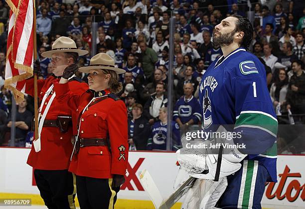 Roberto Luongo of the Vancouver Canucks stands in his crease beside to RCMP officers in Game Four of the Western Conference Semifinals against the...